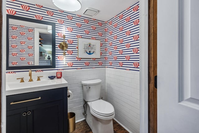 bathroom featuring vanity, hardwood / wood-style flooring, toilet, and tile walls