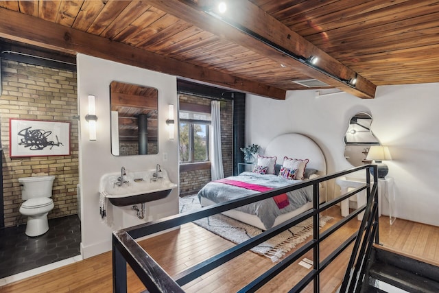 bedroom featuring hardwood / wood-style flooring, beam ceiling, wood ceiling, and brick wall