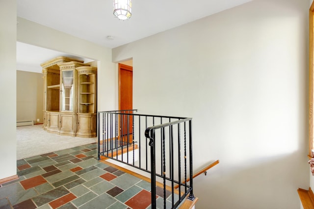 corridor with dark colored carpet and baseboard heating