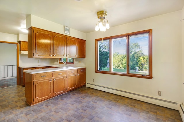 kitchen with kitchen peninsula, pendant lighting, a notable chandelier, and a baseboard heating unit