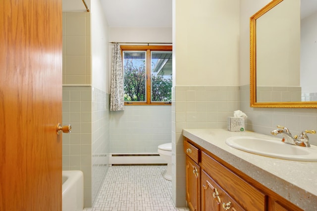 bathroom with tile patterned floors, vanity, a baseboard radiator, and tile walls