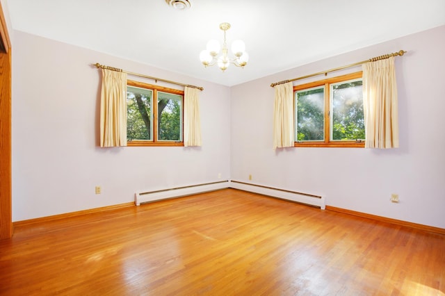 unfurnished room with baseboard heating, hardwood / wood-style floors, and a notable chandelier