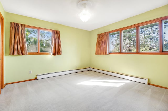 carpeted spare room with a baseboard radiator and plenty of natural light