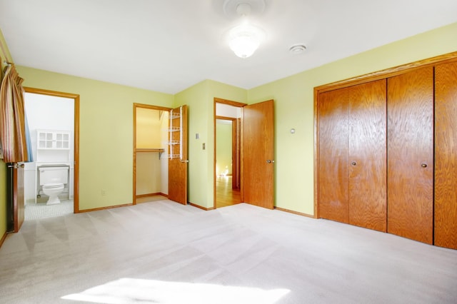 unfurnished bedroom featuring ensuite bath and light carpet