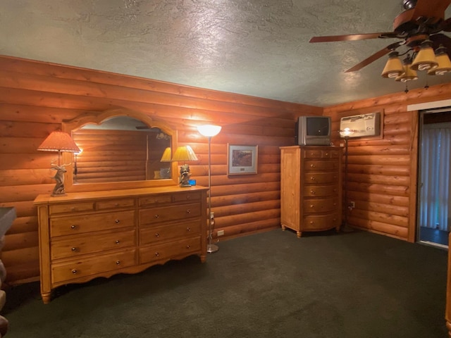 bedroom featuring rustic walls, dark carpet, and a textured ceiling