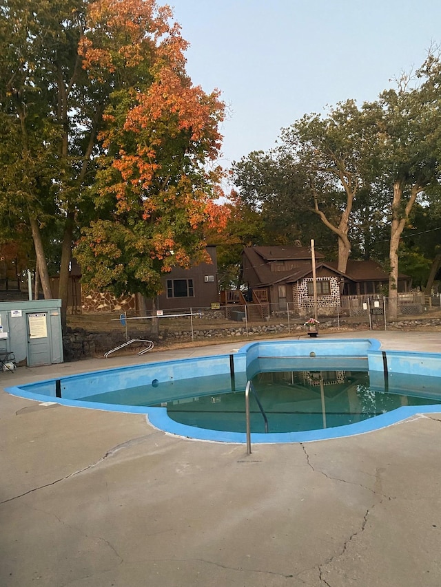 community pool with fence and a patio