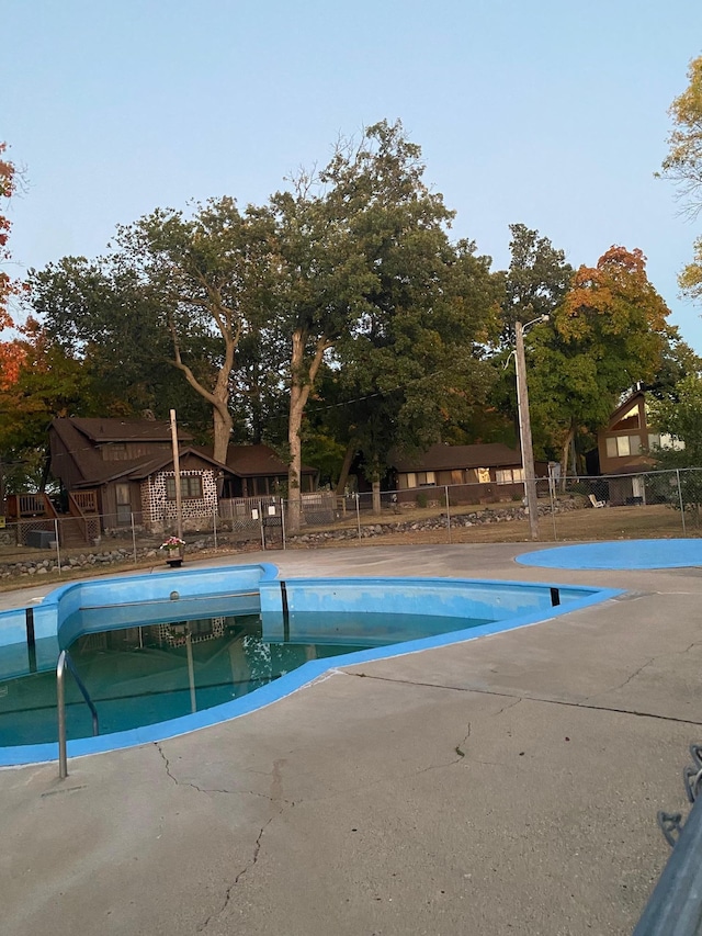 community pool featuring fence and a patio