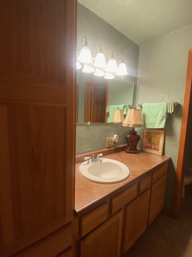 bathroom featuring a textured wall and vanity