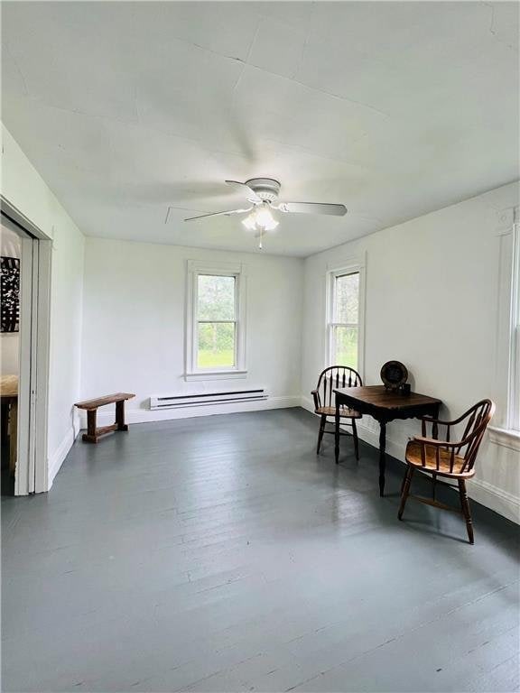 sitting room featuring ceiling fan, a healthy amount of sunlight, and baseboard heating