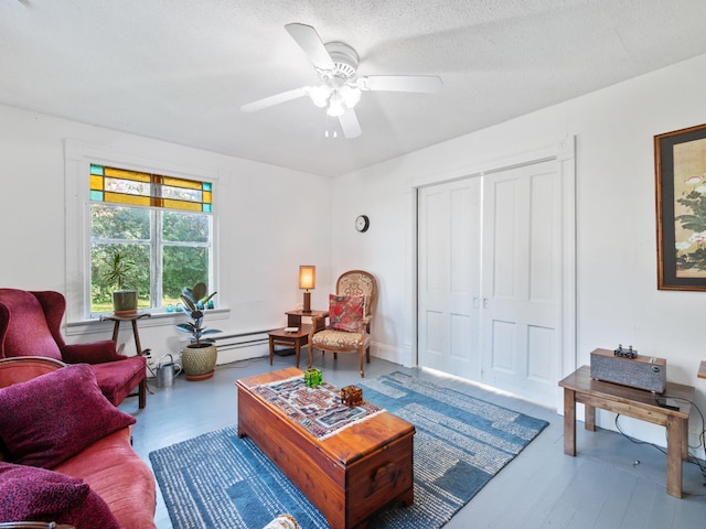 living room with ceiling fan and a textured ceiling