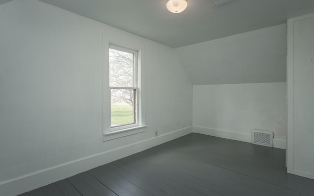 additional living space with dark hardwood / wood-style flooring and lofted ceiling