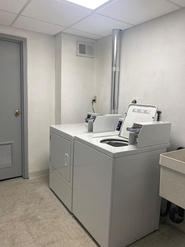 laundry area with light floors, visible vents, and washing machine and clothes dryer