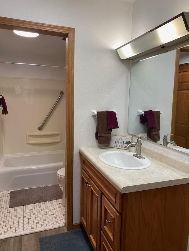 bathroom featuring toilet, shower / bath combination, wood finished floors, and vanity