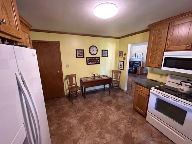 kitchen with ornamental molding and white appliances