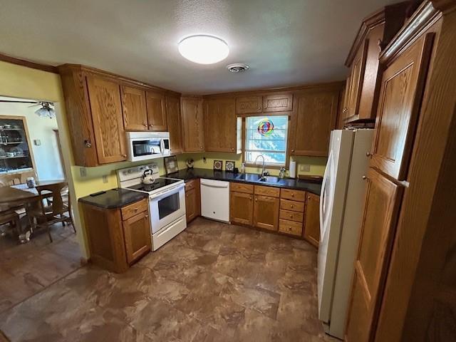 kitchen featuring ornamental molding, ceiling fan, sink, and white appliances