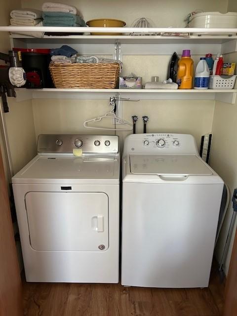 clothes washing area featuring dark hardwood / wood-style floors and washing machine and clothes dryer