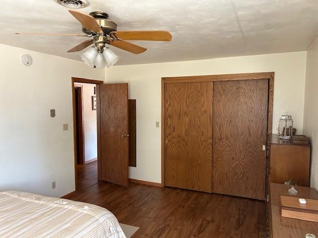 bedroom with a closet, ceiling fan, and dark hardwood / wood-style flooring