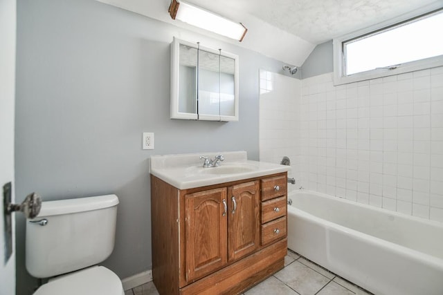 full bathroom with tiled shower / bath, vanity, toilet, tile patterned floors, and vaulted ceiling