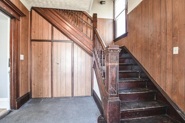 stairway with wooden walls and carpet