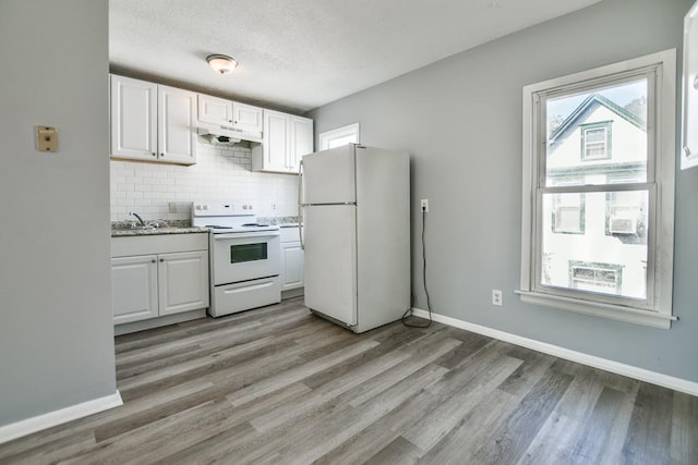 kitchen featuring light wood-type flooring, backsplash, white appliances, and white cabinetry