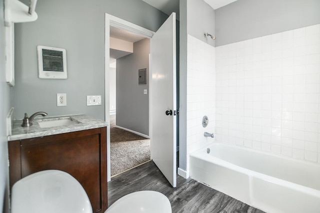 full bathroom with vanity, hardwood / wood-style flooring, tiled shower / bath combo, and toilet