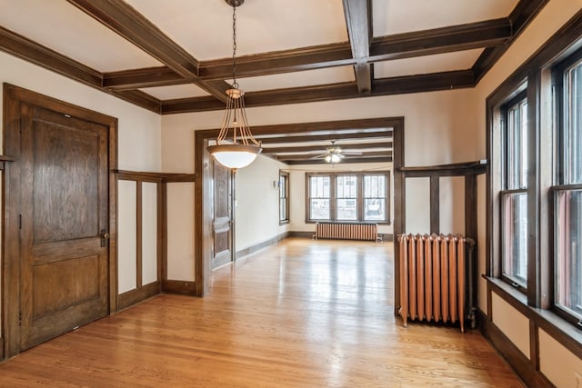 interior space with radiator heating unit, ceiling fan, coffered ceiling, and beam ceiling