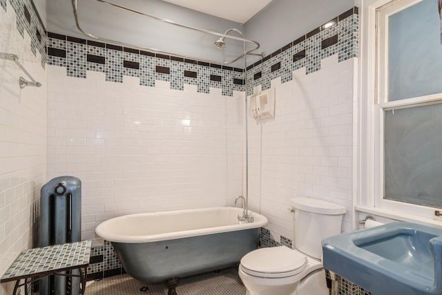 full bathroom with sink, toilet, tile walls, and tile patterned floors