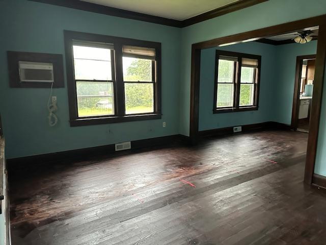 unfurnished room featuring ceiling fan, ornamental molding, plenty of natural light, and dark hardwood / wood-style floors