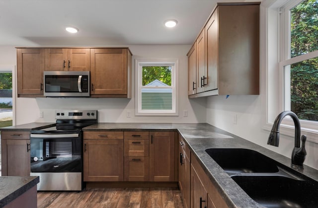 kitchen featuring appliances with stainless steel finishes, sink, and dark hardwood / wood-style flooring