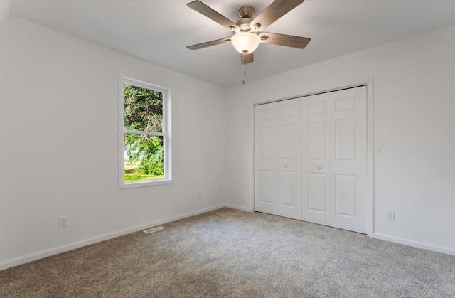 unfurnished bedroom featuring a closet, ceiling fan, and carpet flooring