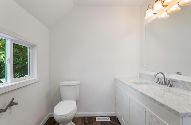 bathroom with a notable chandelier, toilet, vaulted ceiling, vanity, and hardwood / wood-style floors