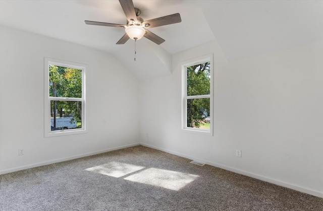 unfurnished room with ceiling fan, vaulted ceiling, carpet floors, and a healthy amount of sunlight