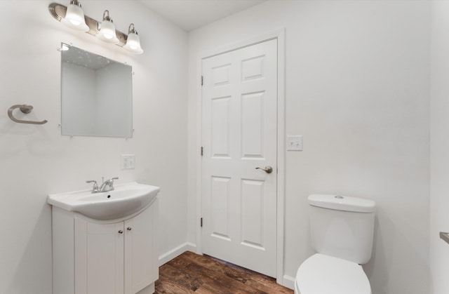 bathroom featuring toilet, vanity, and wood-type flooring