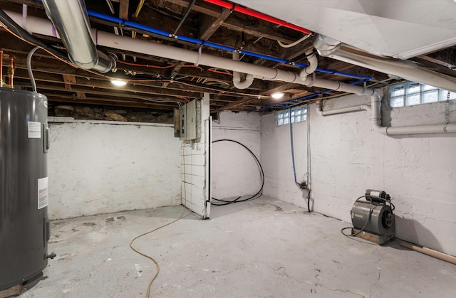 basement featuring water heater and electric panel