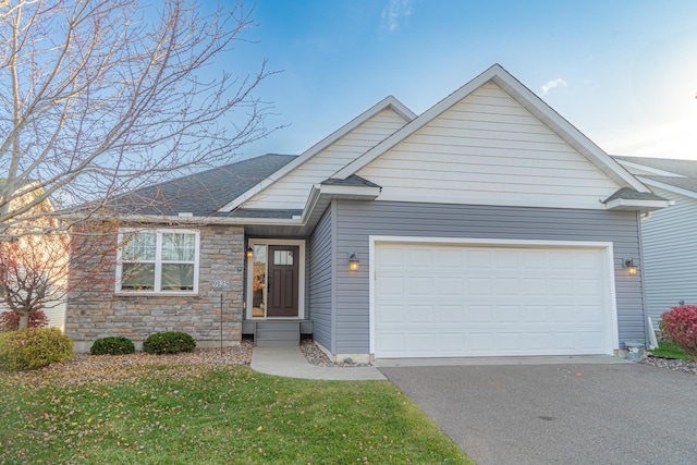 ranch-style house with an attached garage, driveway, a shingled roof, and a front yard