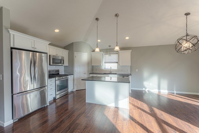 kitchen featuring lofted ceiling, white cabinets, hanging light fixtures, dark hardwood / wood-style flooring, and appliances with stainless steel finishes