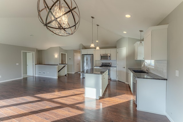 kitchen with white cabinetry, appliances with stainless steel finishes, sink, and a kitchen island