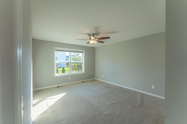 carpeted spare room with ceiling fan and a textured ceiling