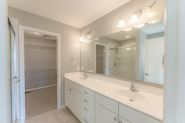 bathroom with a shower with door, vanity, and tile patterned floors