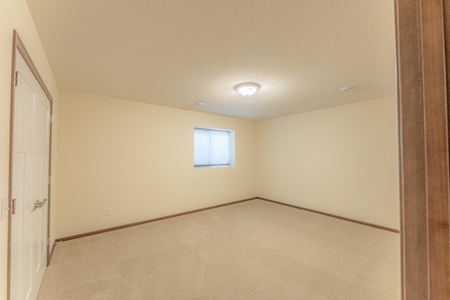 unfurnished bedroom featuring a textured ceiling and light colored carpet