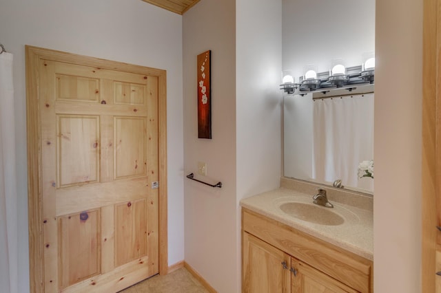 full bath featuring vanity and baseboards