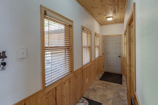 entryway with a wainscoted wall, wood walls, and wood ceiling