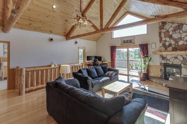 living room with wooden ceiling, beamed ceiling, ceiling fan, light wood-style flooring, and a fireplace