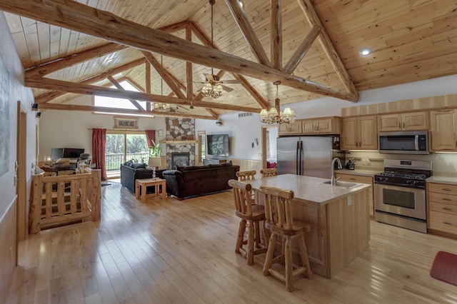 kitchen with light wood-type flooring, a sink, appliances with stainless steel finishes, and light brown cabinetry