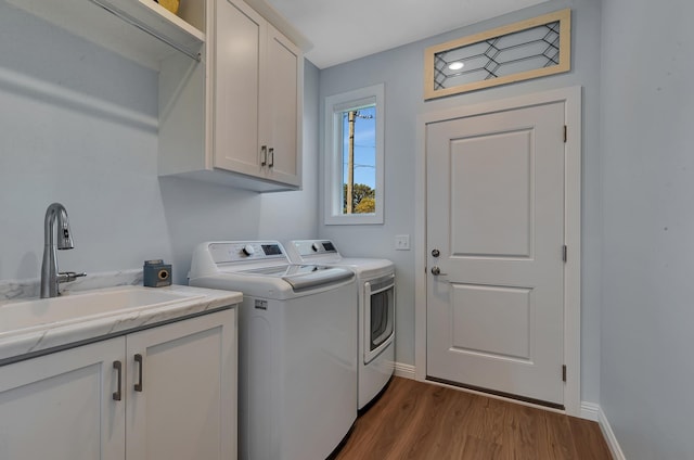 laundry area with sink, light hardwood / wood-style flooring, cabinets, and independent washer and dryer