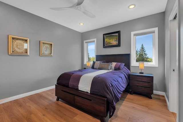 bedroom with multiple windows, light hardwood / wood-style floors, and ceiling fan