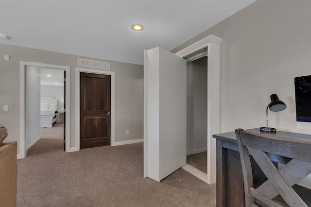 home office with a textured ceiling and light carpet