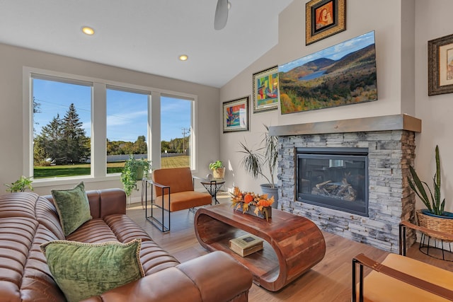 living room featuring light hardwood / wood-style flooring, a fireplace, and vaulted ceiling