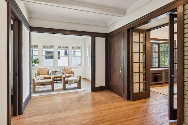 interior space featuring radiator, light hardwood / wood-style floors, beamed ceiling, and french doors