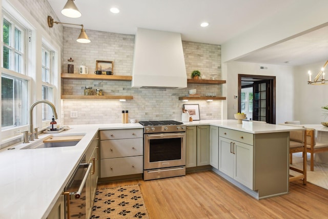 kitchen with stainless steel appliances, a wealth of natural light, and hanging light fixtures